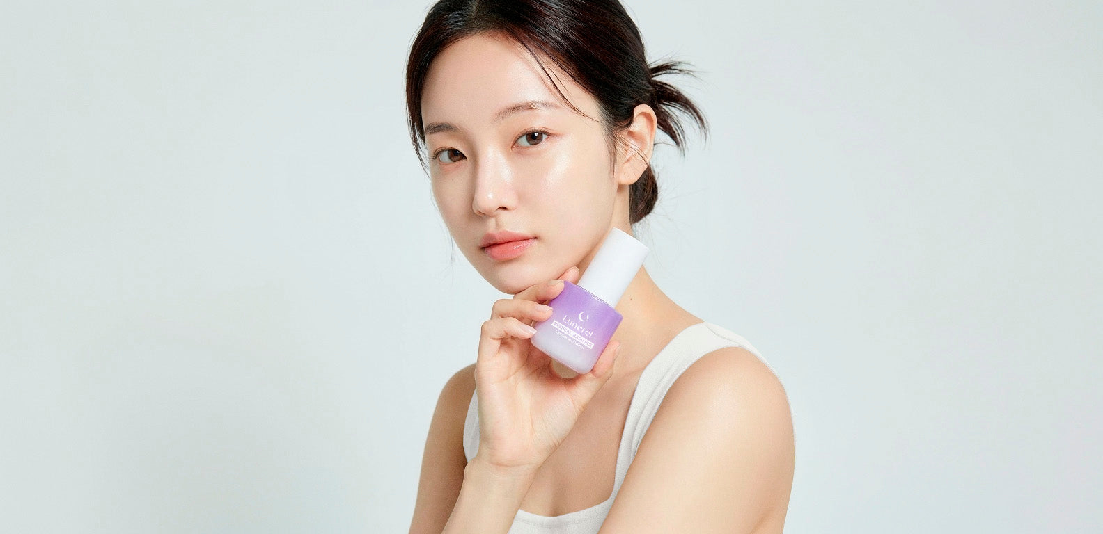 Model holding Lunérel Mystical Radiance Serum with liposomal retinol